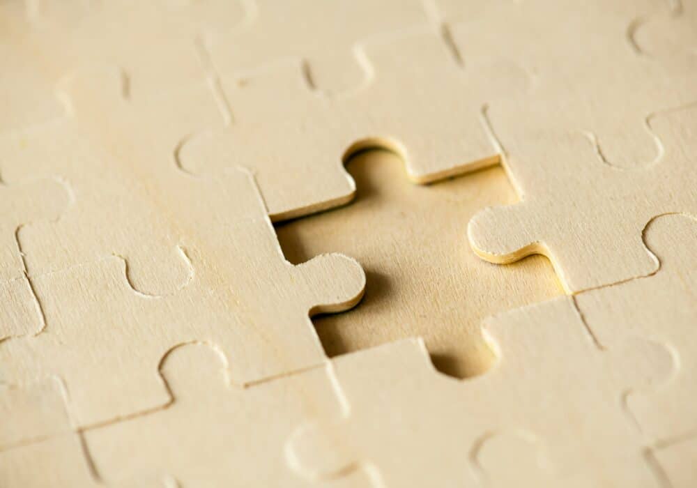 Empty puzzle piece on wooden background.