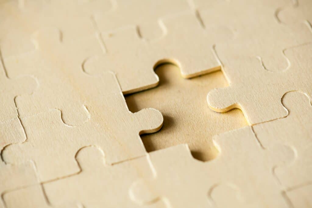 Empty puzzle piece on wooden background.