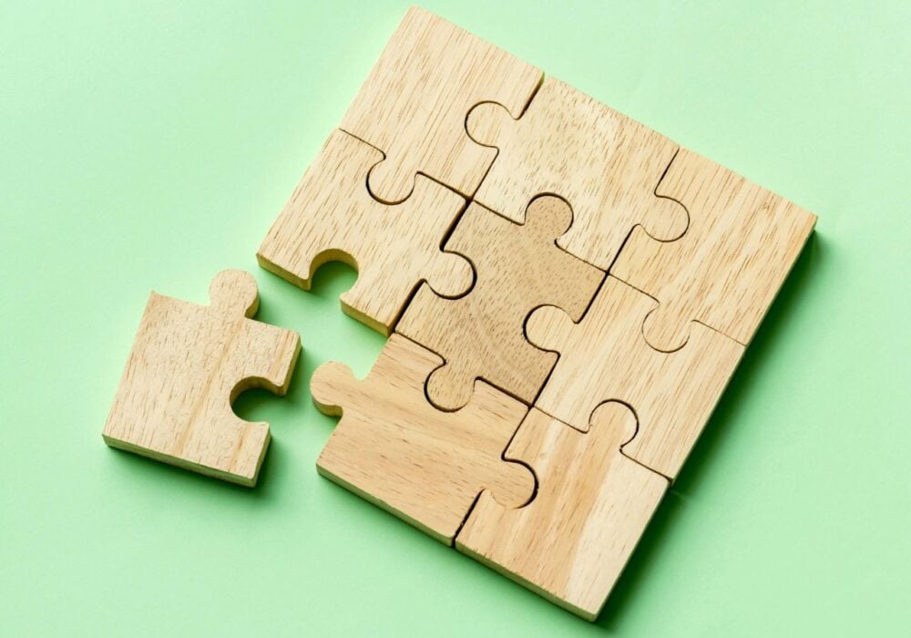 Wooden puzzle pieces on green background