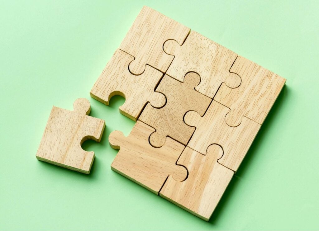 Wooden puzzle pieces on green background